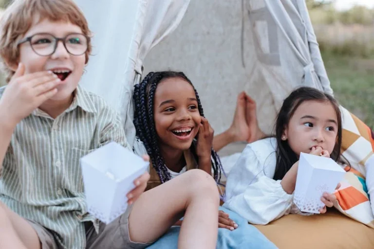 Three young children enjoying a backyard camping experience.