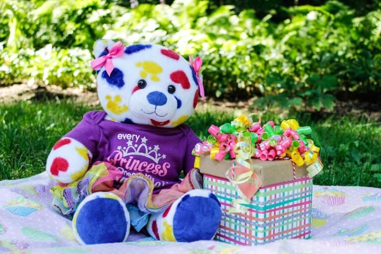 Photo of a Colorful Teddy Bear beside a Gift Box